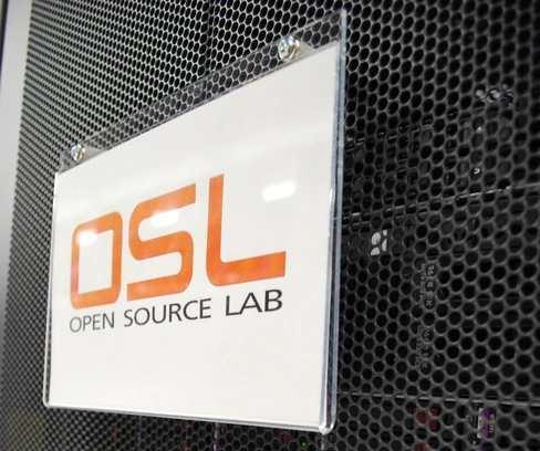 OSL Logo Plate - Image Copyright OSUOSL, Used with Permission A perspex sign on a black, carbon-style wall. In orange capital letters, "OSL"; below, in black, "Lab"